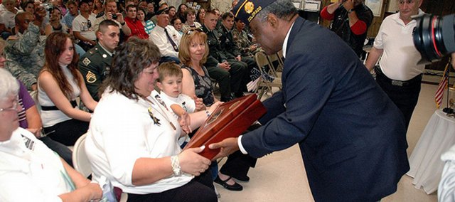 Sherri Lawton, widow of the late Staff Sgt. Mark A. Evans-Lawton, receives a wooden case for the American flag during an August 2006 ceremony honoring her husband and renaming the Craig American Legion Post after him. Sherri Lawton, a former Hayden resident, is asking the community to contact their state lawmakers in hopes of stopping a Flagstaff, Ariz., distributor from selling anti-war T-shirts decorated with the names of fallen Iraq veterans.