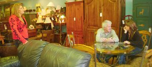 Annie's Home Consignments owner Annie Tisch talks to customers Jack Doyle and Jenny Gentry on Thursday at the store.