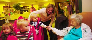 One-year-old Branson Boyce shakes hands with Doak Walker Care Center resident Lila Rider on Thursday morning when children enrolled at the neighboring GrandKids Child Care Center visited residents. Tentative plans call for relocating the nursing home about two miles from the hospital on the southern edge of Steamboat Springs.