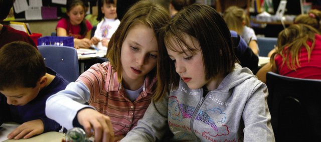 Kinlie Brennise, 7, left, East Elementary School second-grader, works with fourth-grader Tiara Hampton, 10, during a cooperative learning project Friday morning at the elementary school. Brennise and Hampton are a part of a writing program started this year that pairs second- and fourth-graders of similar abilities.
