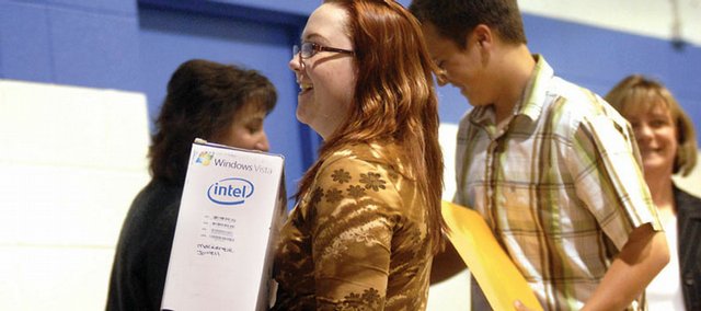 Mackenzie Jowell picks up her new laptop computer Tuesday for completing the Work and Life Skills Coalition program during a recognition ceremony at the Boys & Girls Club of Craig. Seventy-one students received computers for completing the program that assisted with life after high school and how to get and keep a job.