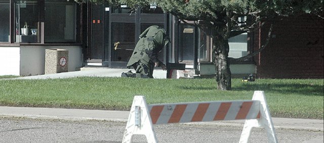 Sgt. Stan Ancell, with the Grand Junction Police Department Bomb Squad, prepares to X-ray a suspicious cooler left outside the Moffat County Courthouse at about 6:30 p.m. Monday while wearing a special blast suit. He was the first person to open the cooler and show other officials at the scene that it did not contain explosives.