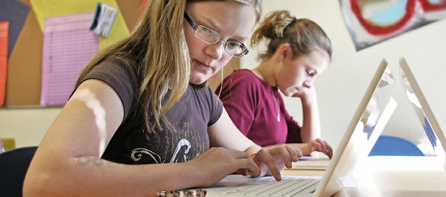 Olivia Cass, left, and Charli Earle, sixth-graders at Craig Middle School, type up stories they've written so far this year while sitting in Judy Harris' literacy intervention class. Harris will upload the stories to a national gallery that will be unveiled on the National Day of Writing, which is Tuesday.