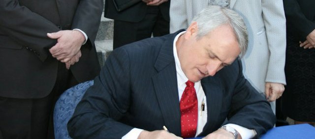 Gov. Bill Ritter signs Colorado House Bill 10-1365, also known as the Clean Air, Clean Jobs Act, on Monday on the steps of the state capitol surrounded by supporters. Several local officials, including the Moffat County Commission, opposed the bill, claiming it would hurt the Northwest Colorado coal industry.