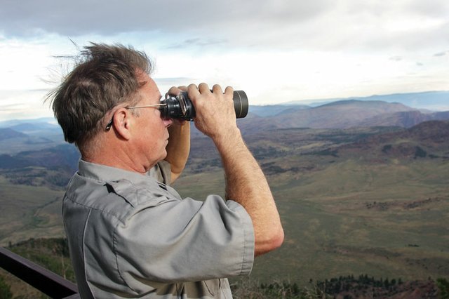 Daniel Hazen, a firewatcher and park ranger for the National Park Service, scans over Dinosaur National Monument in search of smoke, lightning or fire Friday from his lookout tower on top of Zenobia Peak. Hazen usually keeps watch alone in the tower for 10 straight days, sometimes stretching that span during busier parts of the fire season.