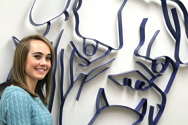 Maddy Jourgensen, a Moffat County High School senior, stands near the school’s mascot Wednesday at MCHS after signing a letter of intent to run for Augustana College in Sioux Falls, S.D. in the fall. Jourgensen received help from her cross-country and track coach, Todd Trapp, and her parents in making the decision.