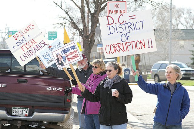 Meeker resident Patti Hoke, right, holds up a sign in protest Friday at the 2011 Tax Day Freedom Rally hosted by the Bears Ears Tea Party Patriots at the Moffat County Courthouse. About 100 residents from the area including Rangely, Baggs, Wyo. and Steamboat Springs attended the event, which featured speakers, music and prizes.