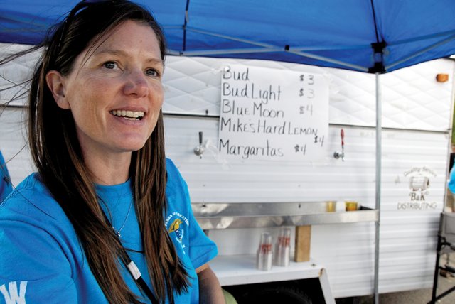 Brec Ronis, a member of the Northwest Colorado Chapter of Parrotheads, takes drink orders Saturday from a concession stand during the Whittle the Wood Rendezvous in Craig City Park. Organizers changed the alcohol policy at this year’s event by not allowing event visitors to bring their own beverages.