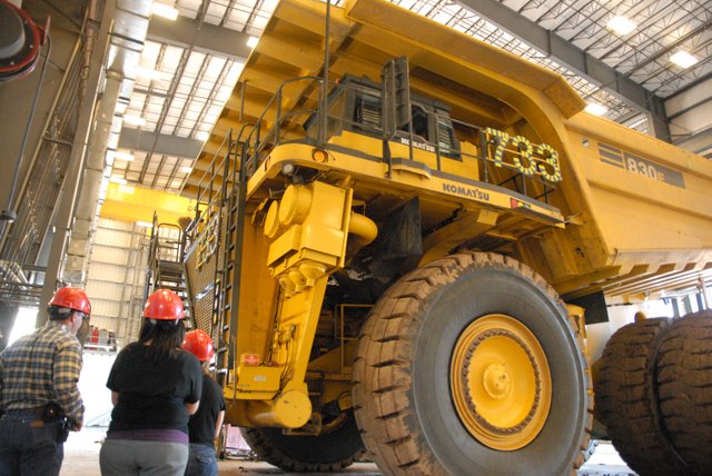 A mammoth dump truck sits Wednesday in a garage at Trapper Mine, Inc. as tour members look on. The tour was part of a busy agenda for representatives of the Colorado Department of Labor and Employment, State Senator Jean White and community leaders. The group also toured Tri-State Generation & Transmission, and participated in an education session to discuss the economic impacts of regional energy industries and the workforce.