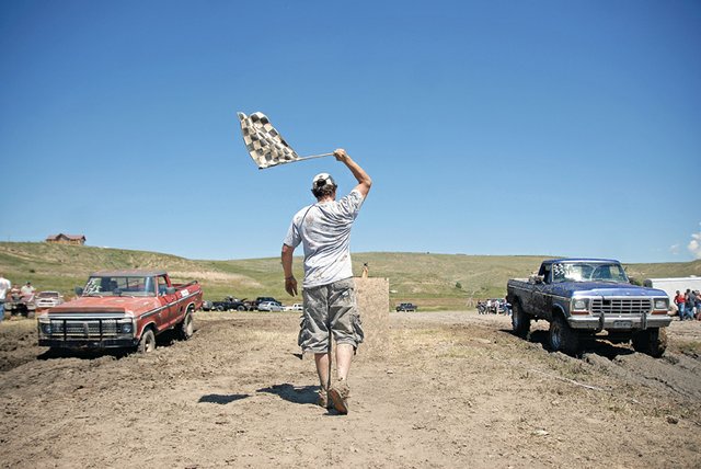 Craig resident Jason Vallejos drops the flag to start a race Saturday during the 2011 Moffat County Mud Runs at Wyman Museum. Gunning their engines are Meeker resident Loren Maybury, left, in a 1973 Ford pickup with a 390 engine, and Craig resident Greg Merrick, in a 1978 Ford pickup with a 460 engine.