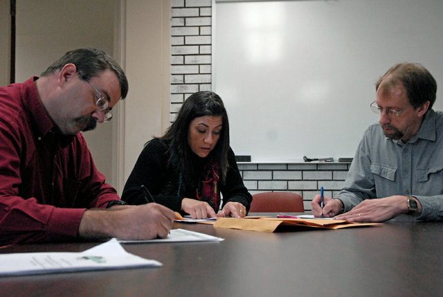 Stephanie Beckett, middle, Moffat County elections supervisor, reads bids from a mineral lease auction Wednesday morning in a Moffat County Courthouse conference room while Jeff Comstock, left, natural resources director, and Dan Davidson, right, director of the Museum of Northwest Colorado, record the results. The auction consisted of 34 tracts totaling 644 mineral acres owned by the county and museum. The auction could net more than $158,000 and $152,000 for the county and museum, respectively, if the Moffat County Commission accepts the bids Jan. 11.