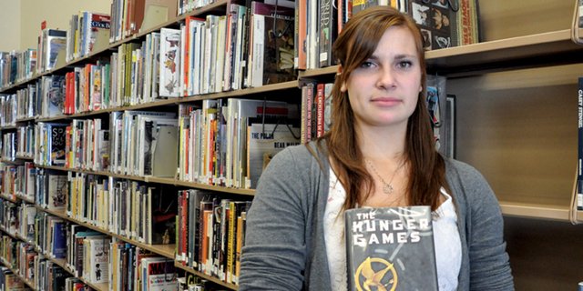 Darby Andrews, a Moffat County High School junior, holds a copy of Suzanne Collins’ “The Hunger Games” in the high school library. When Andrews, 17, learned the school selected the book for its inaugural “One Book, One MCHS” reading program, she was the first to sign up. “I got a bunch of my friends to sign up so we can talk about (the book) after we’ve read it,” she said.