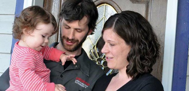 John and Tracey Wall look on as their daughter, Adalynn, 17 months, examines a painted rock John bought from a local vendor in Africa. He gave it to Tracey as a Christmas present before their engagement as a symbol of their mutual desire to return to the country. The Walls, pictured outside their Craig home, are going to Africa together this summer to work with Mercy Ships, a program that offers health care to African residents.