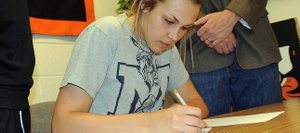 Hayden High School senior Erin Koehler, alongside girls basketball coach Michelle Wilkie and school athletics director Tony Rosso, signs a letter of intent to play basketball at Colorado School of Mines next season.