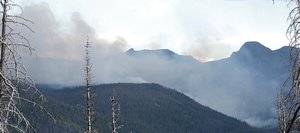 The Wolverine Fire burns a mountainside in the Routt National Forest in August 2005. In the foreground are the charred remnants of trees that fell victim to the Hinman Fire in 2002.