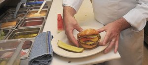 Chris Wyant, executive chef for Steamboat Ski and Resort Corp., puts the finishing touches on a Double Boat Burger at Haymaker Patio Grill. Ski Corp. took over the operation at Haymaker Golf Course this year and brought some of its more successful meals from the mountain to the links.