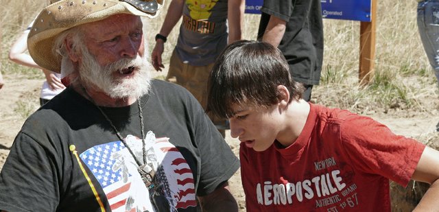 Jan Roth, left, of the Sundance Research Institute, explains to Steamboat Springs High School sophomore Nick Vaughan how to identify the different types of fossilized plants discovered in rocks excavated from a potential Columbian Mammoth site in Craig. The first day of the dig did not yield any mammoth remains, but Roth was encouraged by plant fossils and another discovery of what could be a hearth.