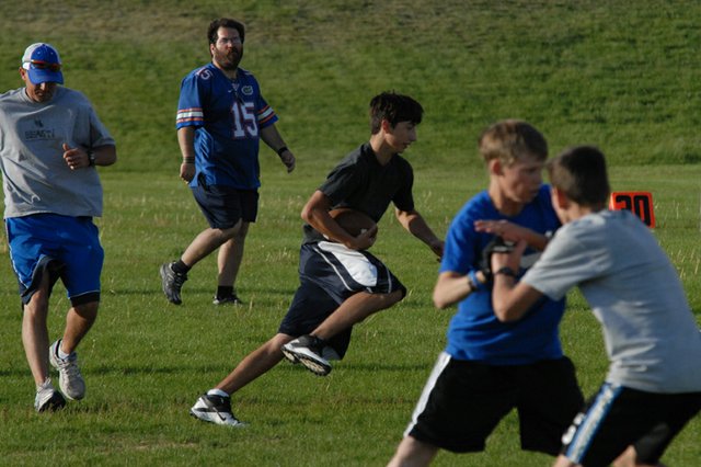 Shandon Hadley, center, runs upfield during a scrimmage for the Moffat County High School football team. Hadley, who will be a freshman at MCHS in the fall, was one of many players who turned out for this week’s practice sessions. The Bulldogs also will attend more intensive camps later this summer.