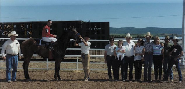 Jockey Jack Brown sits atop Jet Along It after winning a race at the Moffat Country Raceway, set up at the Moffat County Fairgrounds. Standing with the horse and jockey are owner Cap Atwood (left), trainer Marshal Bacon and family. Jet Along It won a half-mile, 70-yard race on June 15, 1985. Craig played host to three weeks of horse racing every summer from the late-1960s to mid-1980s