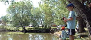 Adrian Bowman, 8, eagerly awaits a bite on his line Saturday at Walton Pond during the 30th annual Fishing Derby organized by the Optimist Club of Steamboat Springs. Eighty-five children participated in the event, catching 43 fish total.