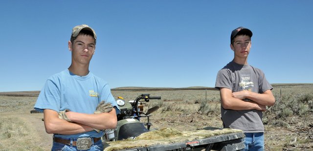 Tyler Gerber, 15, left, and his brother Kearn, 14, stand near a four-wheeler they used Wednesday to repair fence on the family ranch after Tuesday’s Sand Fire about 10 miles west of Craig. Tyler saw the blaze soon after it ignited, and he was “praying that it wouldn’t get on our place, but that didn’t happen,” he said. The fire blackened parts of their grazing land but did not damage the family’s home.