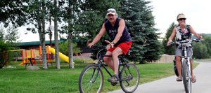 Larry and Susan Henchel pedal down the sidewalk along River Road on Sunday in Steamboat Springs. The day’s clouds didn’t stop waves of cyclists from taking to Steamboat’s streets. The weather likely won’t do much to stop Bike to Work Week, either, which begins today.