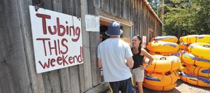 Derek Berglund, back to camera, and Janelle Samora, of Boulder, stopped by the tube rental window at Back Door Sports on Friday afternoon to ask about conditions before deciding if they wanted to go tubing on the Yampa River. The Yampa River rose above 85 cfs Friday allowing tubing to resume on the river as long as the flow remains above that level.