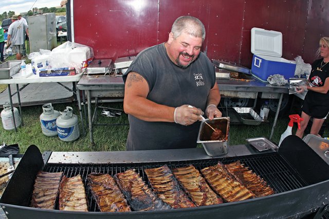 Lionel Cunningham, with the Florida Skin & Bones team, grills racks of ribs to sell during the 2010 Colorado BBQ Championships in Craig. This year’s event will go on as scheduled, after being issued a tentative permit from the Moffat County Sheriff’s Office. However, organizers must take special precautions and may have to cancel the event if unexpected fire hazards arise.