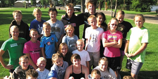 Members of the Craig Sea Sharks are shown with Kelsey Conci, center, after the team’s practice Monday morning. Conci, a 2008 Moffat County High School graduate and competitor at the 2012 Olympic Swimming Trials, helped the Sea Sharks with practice Monday and Tuesday as the team prepares for state competitions.