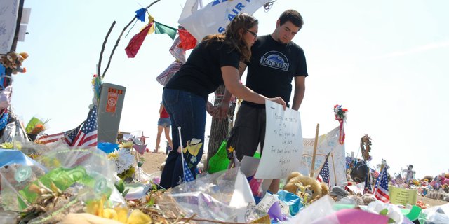 Jacque Archuleta, 24, a Craig native and Englewood resident, and her boyfriend, Alex Espinoza, visit memorials Friday near the Century Aurora 16 multiplex, the scene of one of the worst shootings in U.S. history. The couple was in theater 9 when a gunman opened fire during a midnight screening of "The Dark Knight Rises."
