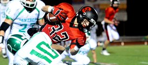 Steamboat's Mitch McCannon is dragged down by a pair of Delta defenders Friday night. Steamboat lost, 35-0.
