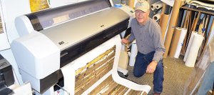 Photographer Don Tudor pulls an image of fall aspen trees from the printer Tuesday morning in the back room at the Sleeping Giant Gallery. The gallery at 601 Lincoln Ave. is closing at the end of November after nine years in downtown Steamboat Springs.