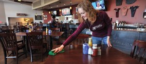Employee Karleen Booco cleans off tables at Three Wire Bar & Grill at Yampa Valley Regional Airport on Thursday afternoon. The restaurant, which is run by the county, was created during the last phase of improvements and has been operating at a loss during its first year.