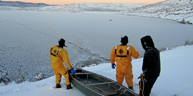 Yampa River State Park rangers Matt Schuler, left, and Jacob Dewhirst, middle, prepare to launch a boat Friday with Park Manager Ron Dellacroce in an effort to save two mule deer fawns trapped in the ice at Elkhead Reservoir. The joint Bureau of Land Management, Colorado State Parks rescue effort was a success.