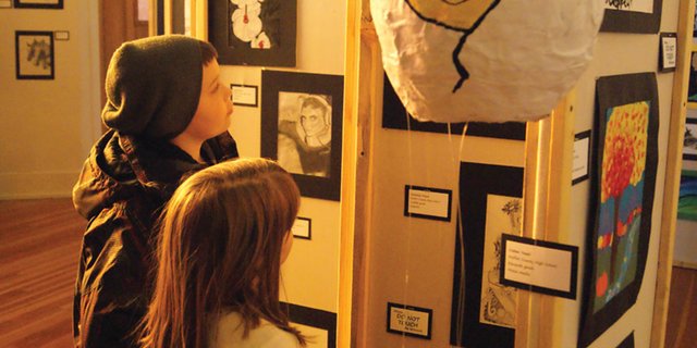 Hayden Short, 10, left, and his sister Ruby Short view the artwork at the Connections 4 Kids Cherish the Little Things Children's Art Show. Ruby's piece was chosen as one of twenty finalists in fifth grade and under chosen by a panel. Visitors to the show may vote by making a monetary donation to Connections 4 Kids.