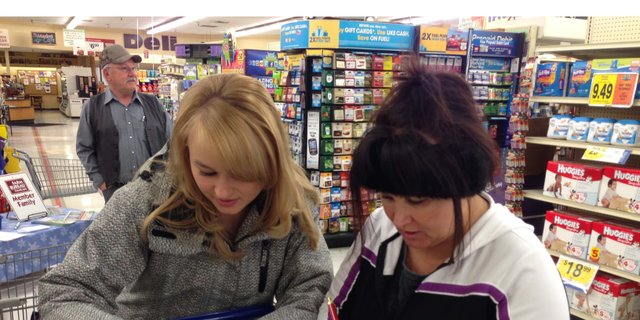 Jade Stees, left, and her mom, Margaret Stees, take a guess at the cost of a cart full of groceries Sunday at City Market in Craig. The Moffat County Farm Bureau and Moffat County Cattlewomen hosted Food Check-Out Day to remind shoppers that their food comes from farmers and ranchers and not just the grocery store.