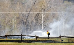 A Steamboat Springs Fire Rescue firefighter works to put out a wildfire Monday morning in Strawberry Park.