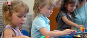 Taytum Smercina, from left, Kimber Wheeler and Nena Loya play at a table with other kids and their teacher, Ms. Carol Taylor.