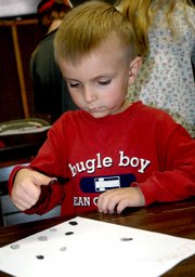 Colton Clark leaves his finger print on a piece of paper for one of his classmates at Friday's Northwest Colorado Home School Association session. Clark and other home-schooled children spend every other Friday learning lessons together.