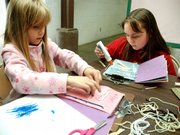 Rebekah Clark, left, and Hannah Cox work on adding a page of history to their homemade history books. On Friday, the students learned about ancient Egypt at the Northwest Colorado Home School Association's bimonthly group teaching sessions.