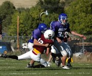 Craig Middle School defensive tackle Tyler Hildebrandt, left, sacks Soroco quarterback Nic Paxton. Hildebrandt and Bubba Ivers, right, led the Bulldog defense in the second half Tuesday, shutting down Soroco's offense on their way to the team's fourth victory in five games.