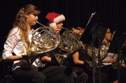 Holiday spirit is in the air Tuesday night, as French horn player Chris Griffin dons a Santa hat during the Moffat County High School Concert Band's winter concert. Several other band members also wore holiday-themed hats and headbands, some featuring reindeer antlers.