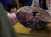 Emily Holloway, 5, looks at a piece Wednesday called "Card Shark" created by Stefan Pell at the MCHS senior art show at Serendipity Coffee Shop. Art teacher Tom Duncan said it was his first year running the show.