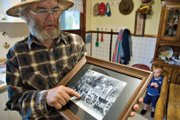 Lex Burton points to an old photo of his family on a horse-drawn wagon taken when he was a child growing up in Browns Park.