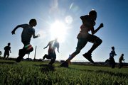 Isaac Filip, 11, center right, plays football with his friends while his two older brothers play in the varsity game. Filip, a sixth-grader, played on the junior varsity team, which won, 49-25.