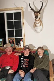 Wesley Chapman, 15, sits between his grandparents, Melvin and Holly Norman, a day after returning home to Craig from a trip through New Zealand.