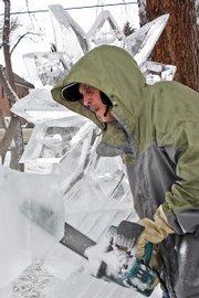 Buddy Cassaday cuts through a 300-pound block of ice with a chainsaw specially tuned and sharpened for his trade Friday at Alice Pleasant Park. Cassady starting sculpting ice in 1982 and has worked with Michael Campe since 1985 as a chef and sculptor.