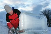 Michael Campe edges a block of ice at the entrance of an ice castle in its beginning stages Thursday at the Wyman Museum. Campe considers the chainsaw his most valuable tool when creating ice sculptures.