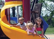 At left, Rhondy McKnight, 2, his twin, Rikki, middle, and Briana Woods, 4, play on the slide Friday at Loudy-Simpson Park. The children said they had as much fun running up the slide as going down it.