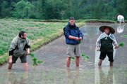 Andrew Christensen, of Craig, helps out in a rice field in China while traveling through Asia. Christensen, 30, sold his house and quit his job to go on the three-month journey through eight African and Asian countries.
